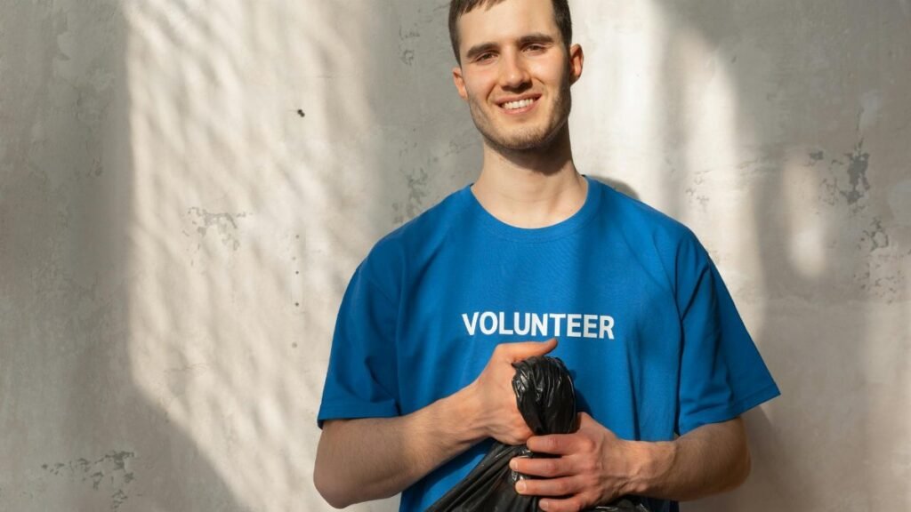 Smiling volunteer holding a garbage bag during a community cleanup effort. Bright and positive environmental action.