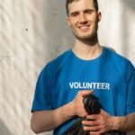 Smiling volunteer holding a garbage bag during a community cleanup effort. Bright and positive environmental action.