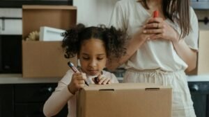 A mother and her daughter pack boxes while moving into their new home, embracing family life.