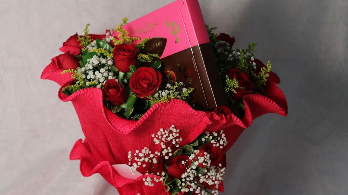 Elegant bouquet of red roses with a gift box, perfect for special occasions.