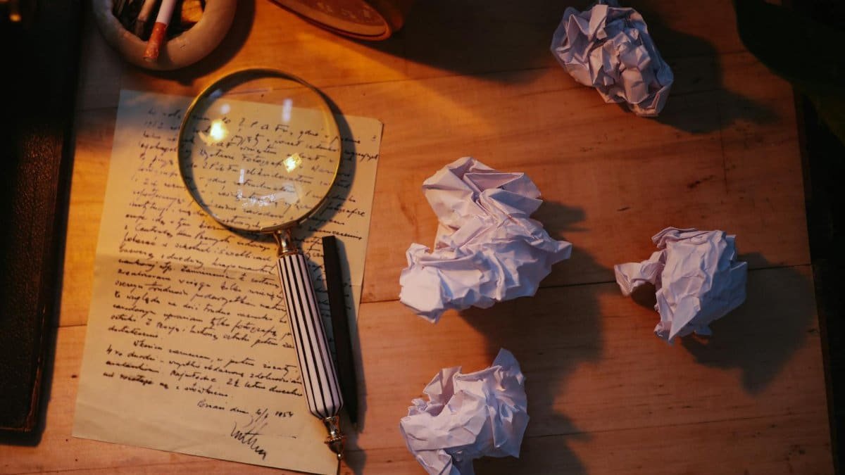 A dimly lit desk with crumpled papers, a handwritten letter, and a magnifying glass, evoking a vintage detective vibe.