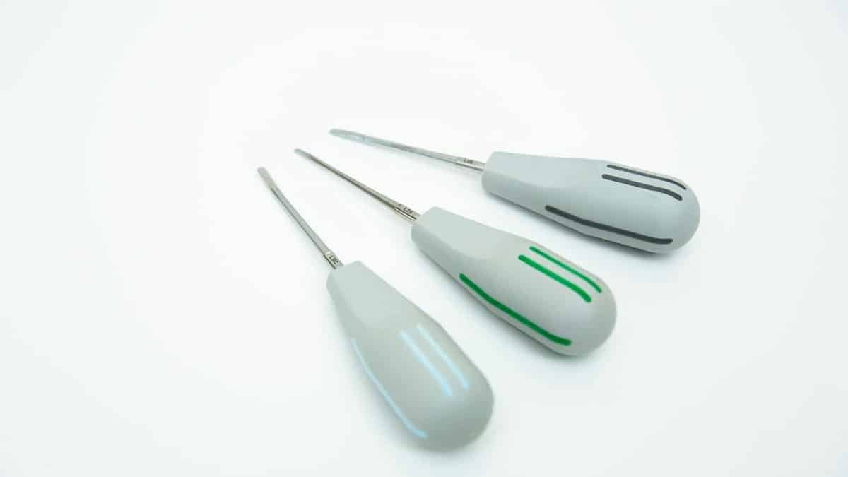 Close-up of three precision tools with gray handles and colored stripes on a white background.