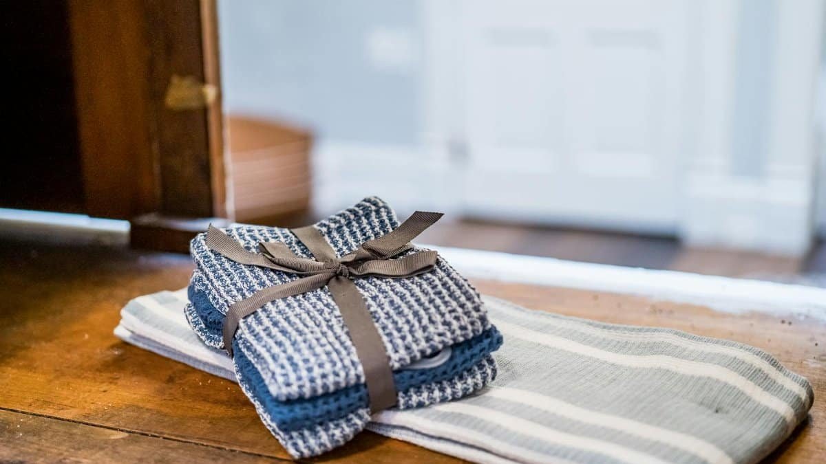 Close-up of rustic linen towels neatly stacked on a wooden surface indoors.