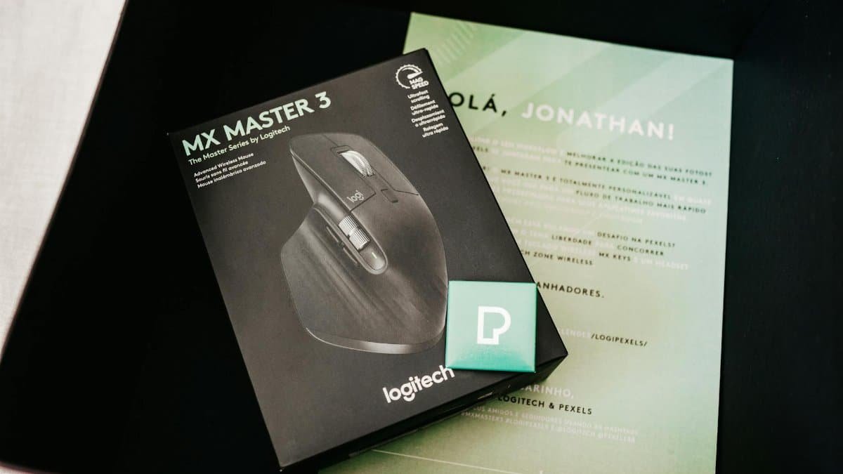 Close-up of a Logitech MX Master 3 mouse box with documentation and a Pexels card.