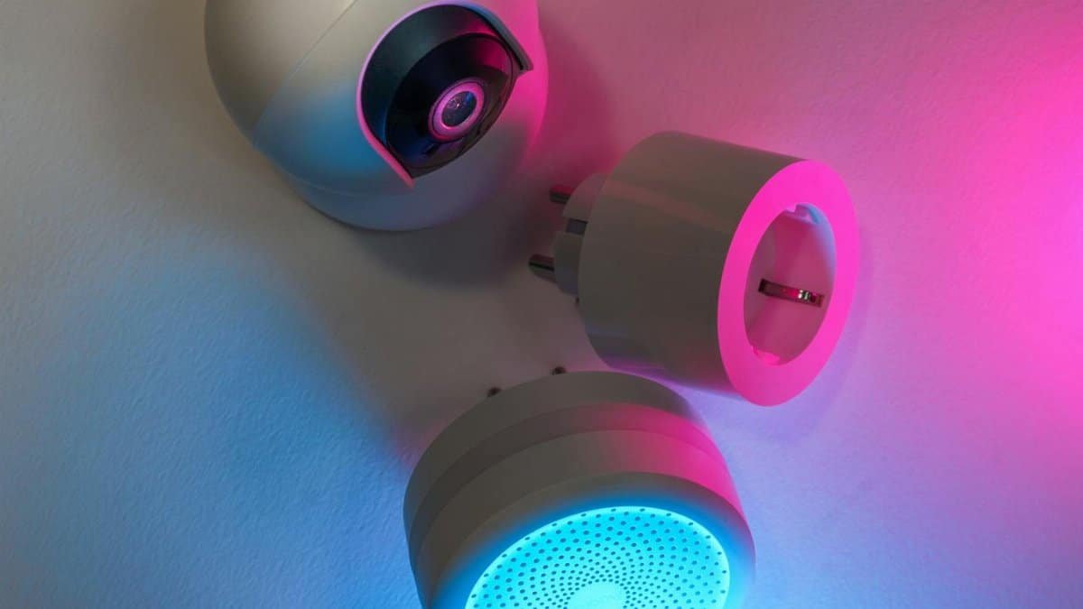 Three smart home devices illuminated by blue and pink neon lights, showcasing technology innovation.