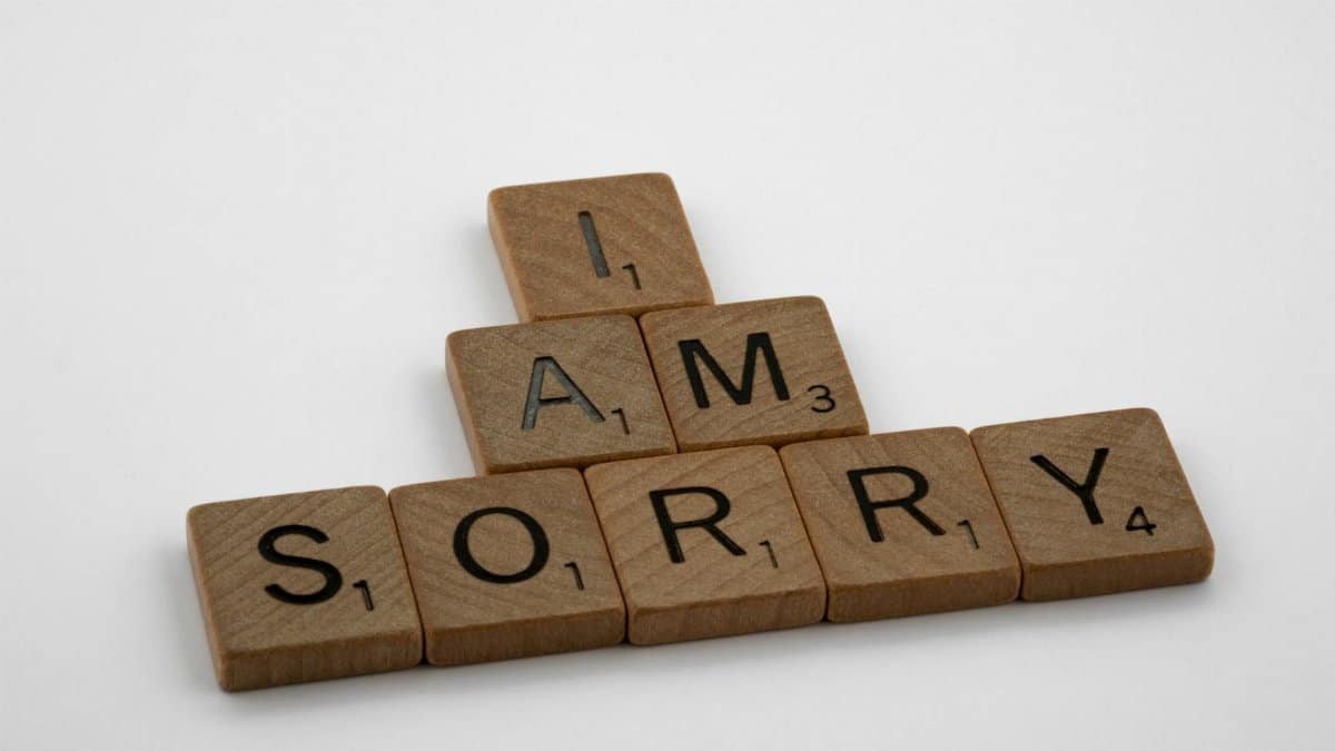 Wooden Scrabble tiles arranged to say 'I Am Sorry' on a clean white background, conveying a message of apology.