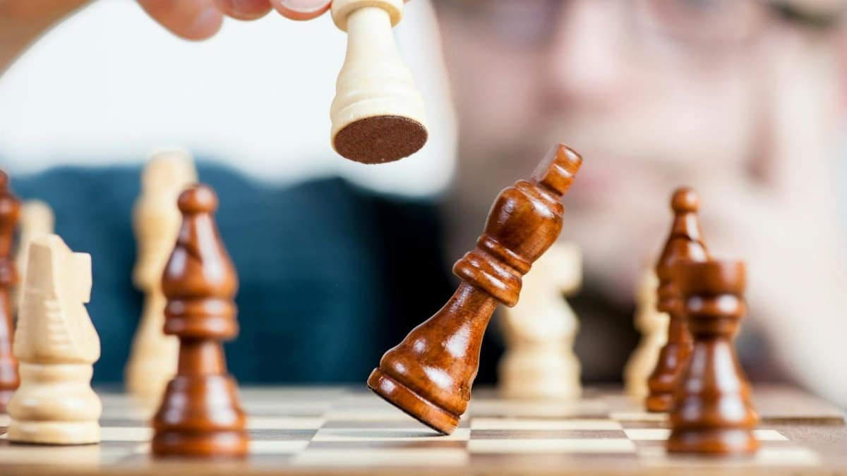 Close-up of a chess game with a focused player, emphasizing strategy and competition.