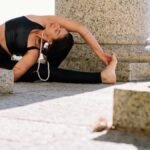 Woman practicing yoga in an outdoor stone setting, radiating serenity.