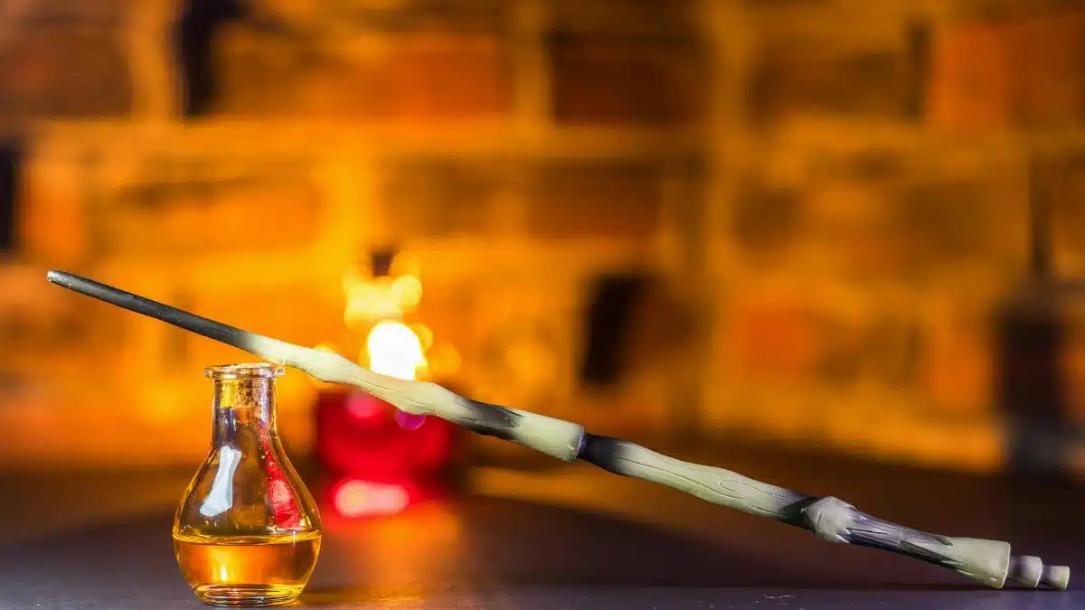 A mystical scene featuring a magic wand and potion bottle set against a warm blurred background.