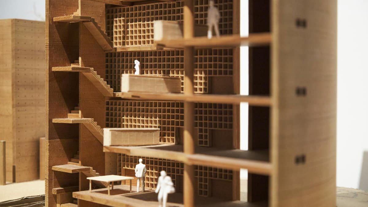 Detailed wooden model showcasing the interior layout of a multi-story building with miniature figures.