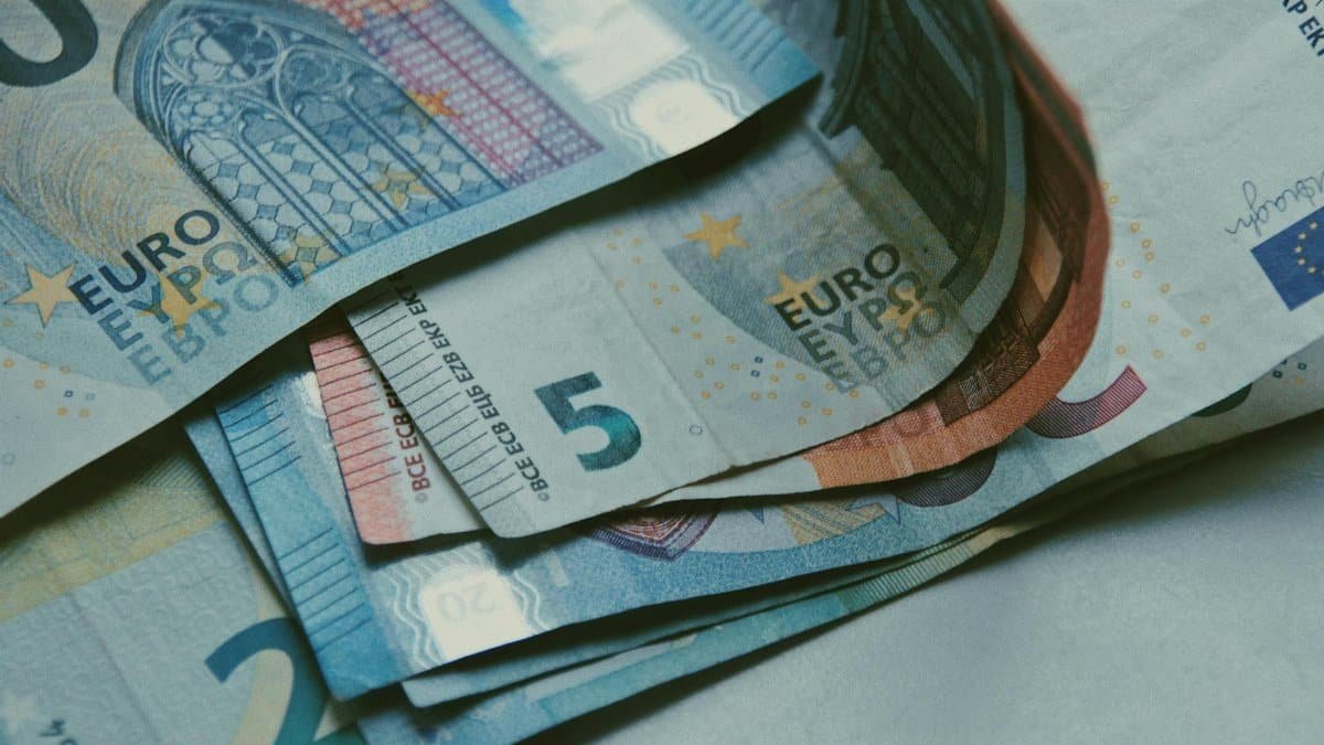 Detailed close-up of various Euro banknotes on a white surface, perfect for finance-related content.