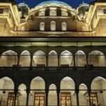 The Yeni Cami Mosque in Istanbul illuminated during the evening, showcasing its Ottoman architecture.