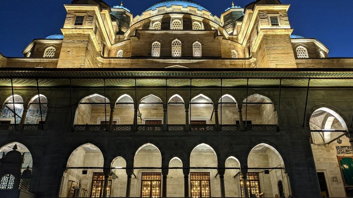The Yeni Cami Mosque in Istanbul illuminated during the evening, showcasing its Ottoman architecture.