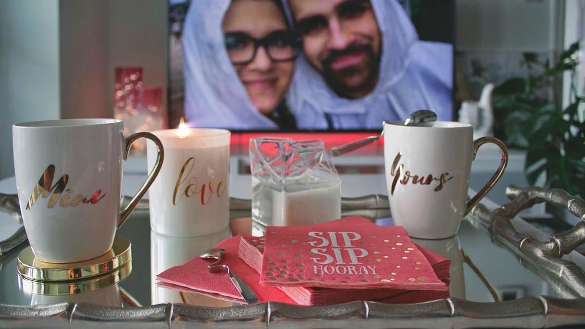 Cozy setting with personalized mugs, candle, and couple's photo, perfect for a romantic coffee date.