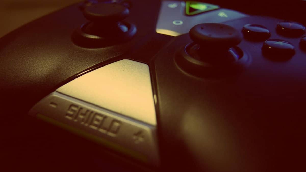 Close-up view of a modern gaming controller, highlighting joystick and buttons with a 'shield' design.