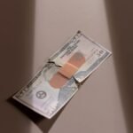 A $50 bill with a bandage symbolizes financial recovery and repair.