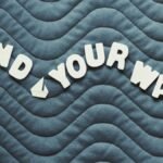 Motivational quote 'Find Your Way' on wave pattern background with heart icon.