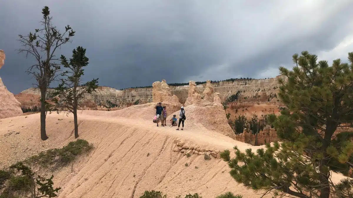 Explore Bryce Canyon's stunning landscapes with hikers on a scenic trail surrounded by iconic geological formations.