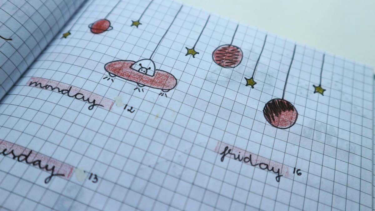Close-up of a hand-drawn weekly planner page with cute, creative designs and grid layout.