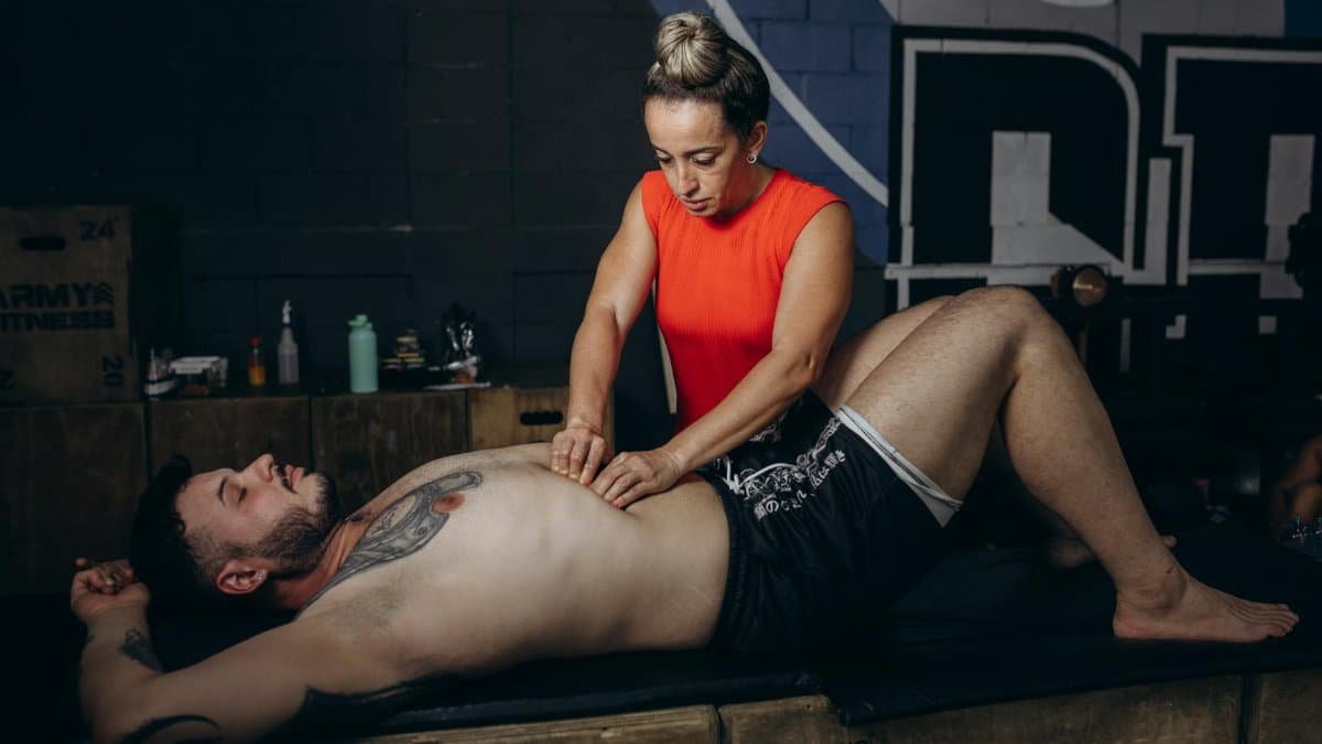 A man receiving deep tissue massage therapy for recovery and muscle relaxation indoors.
