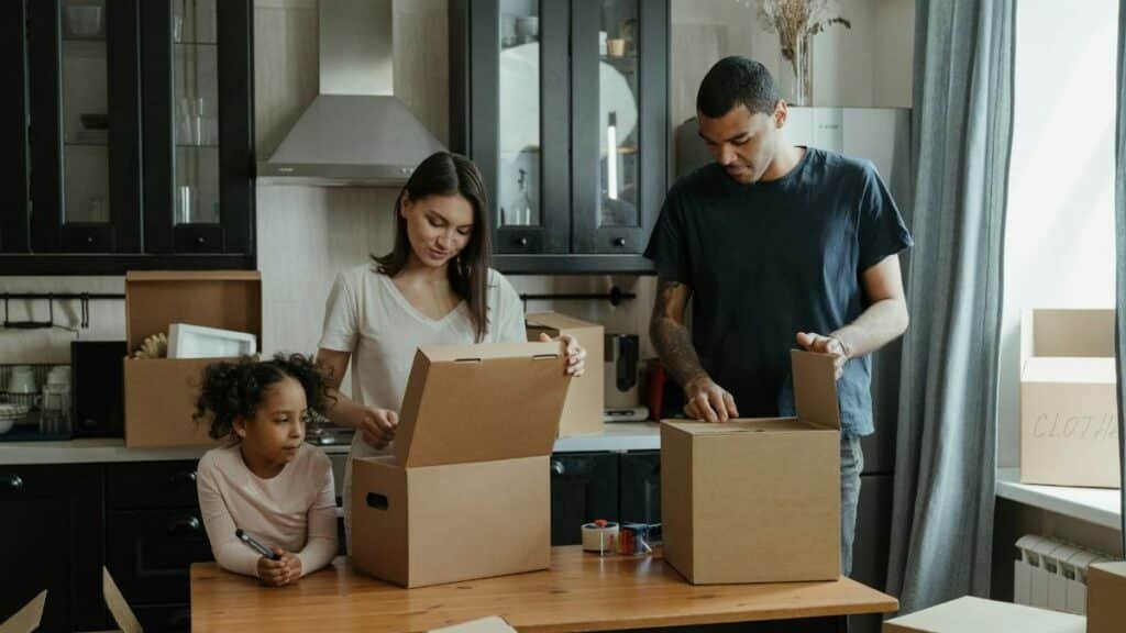 Family unpacking boxes in their new kitchen, enjoying a fresh start in a cozy home.