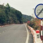 Quiet rural road in the countryside featuring a no overtaking sign and lush greenery.