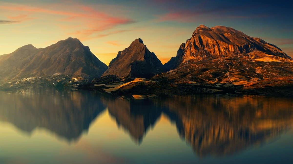 Captivating mountain scenery reflected on a tranquil lake at sunset.