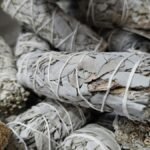 Close-up of dried white sage bundles used for smudging and cleansing rituals.