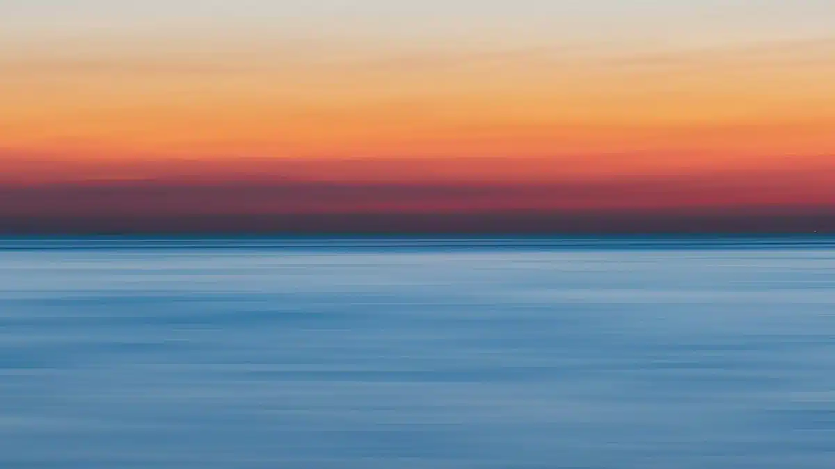 A colorful sunset over a calm ocean, perfect for vibrant backgrounds.