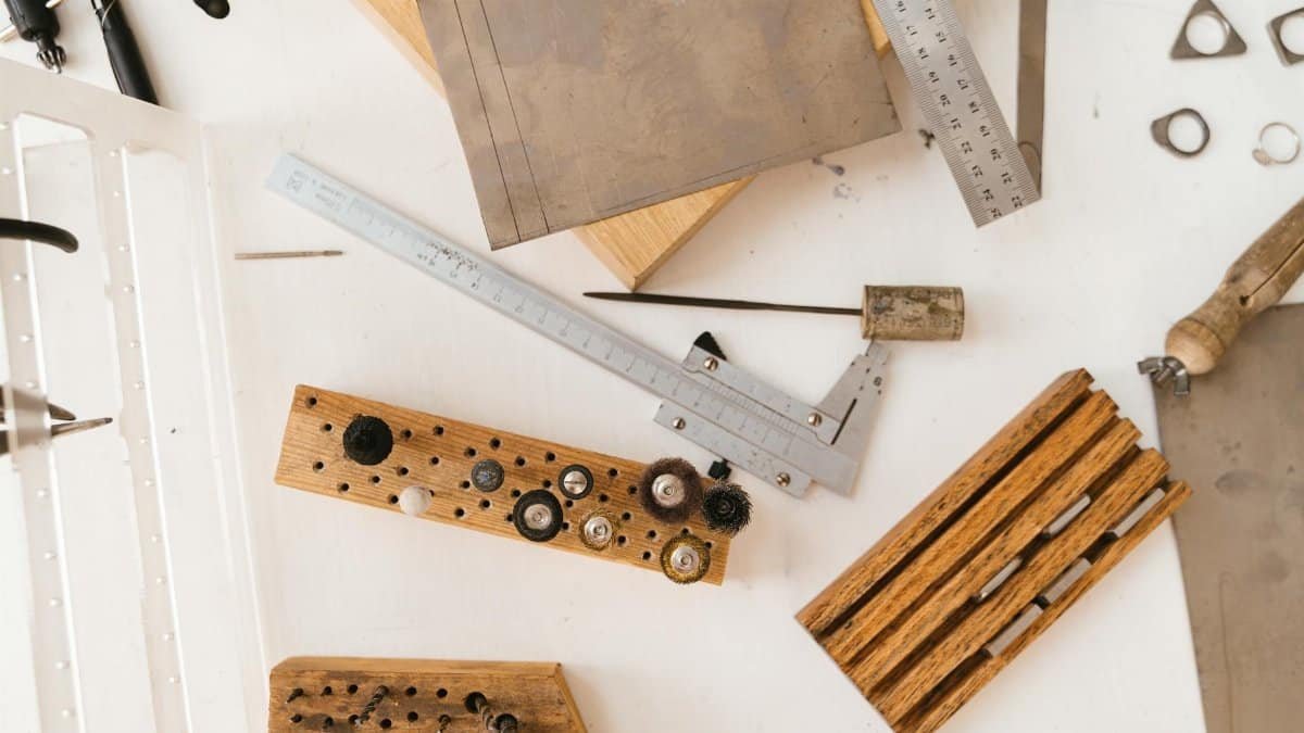 Top view of various crafting tools laid out on a white desk, perfect for creative projects.