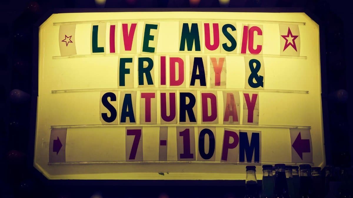 Illuminated vintage marquee promoting live music nights on Friday and Saturday.
