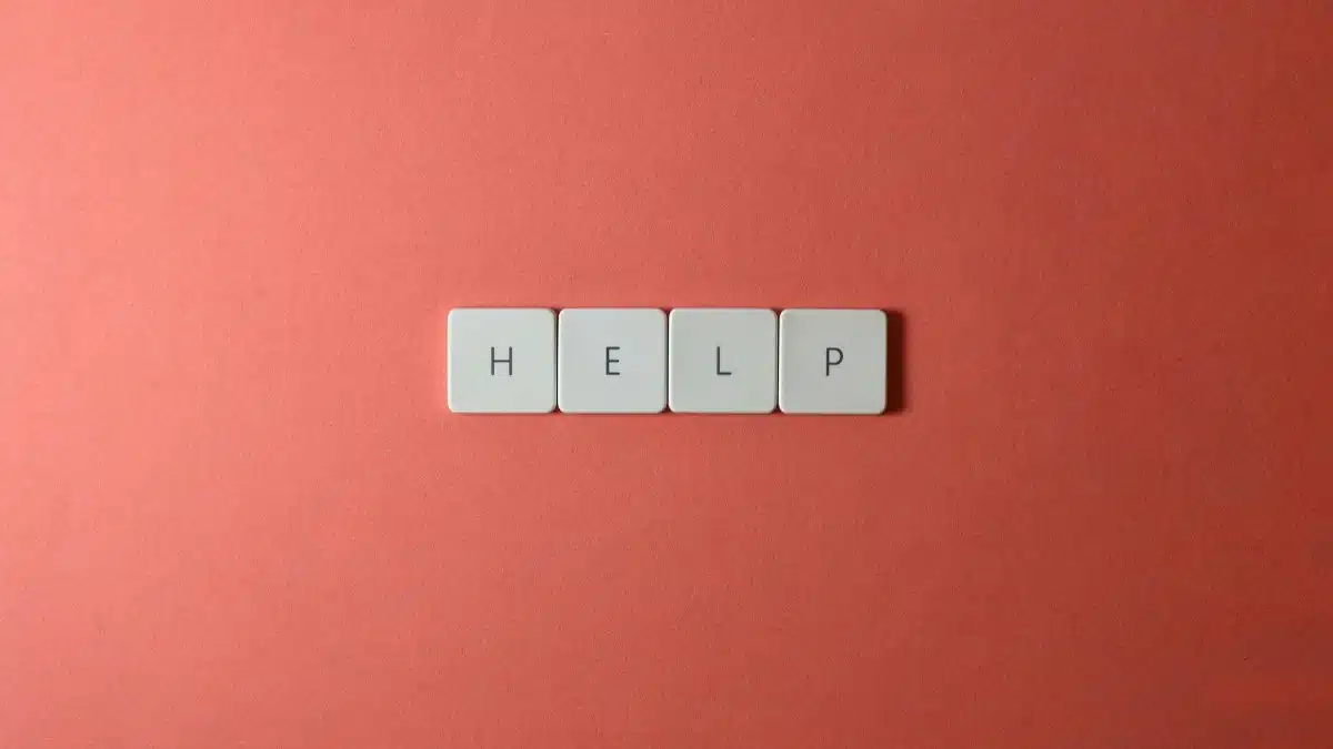 Creative layout of keyboard tiles spelling 'Help' on a red background, offering copyspace.