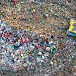 Aerial shot of a landfill site in West Java, Indonesia with visible waste management activity.