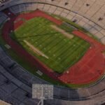High-angle aerial view of an empty stadium with a field and track, showcasing its architectural design.