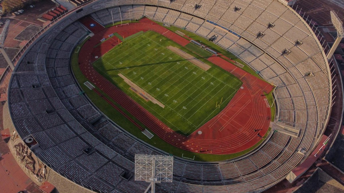 High-angle aerial view of an empty stadium with a field and track, showcasing its architectural design.