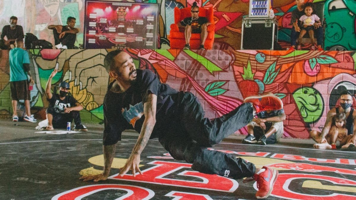 Energetic breakdancer performs on a vibrant street art backdrop. Captures the essence of hip-hop culture.