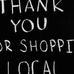 A chalkboard with handwritten message thanking for supporting local businesses.