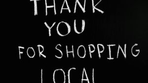 A chalkboard with handwritten message thanking for supporting local businesses.