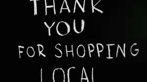 A chalkboard with handwritten message thanking for supporting local businesses.