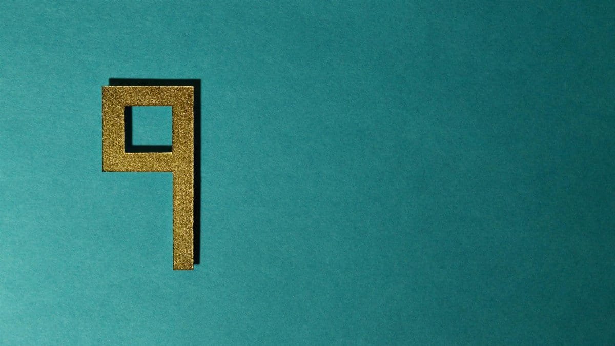 Golden number nine on a teal textured background, perfect for design or art projects.