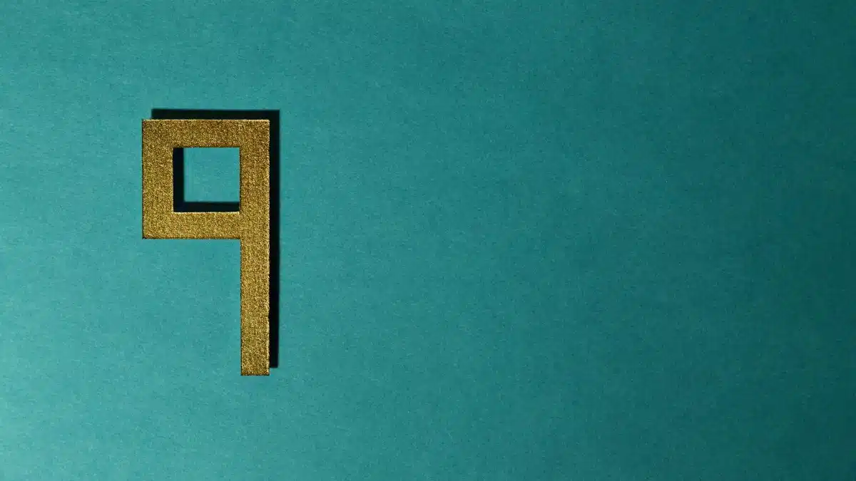 Golden number nine on a teal textured background, perfect for design or art projects.