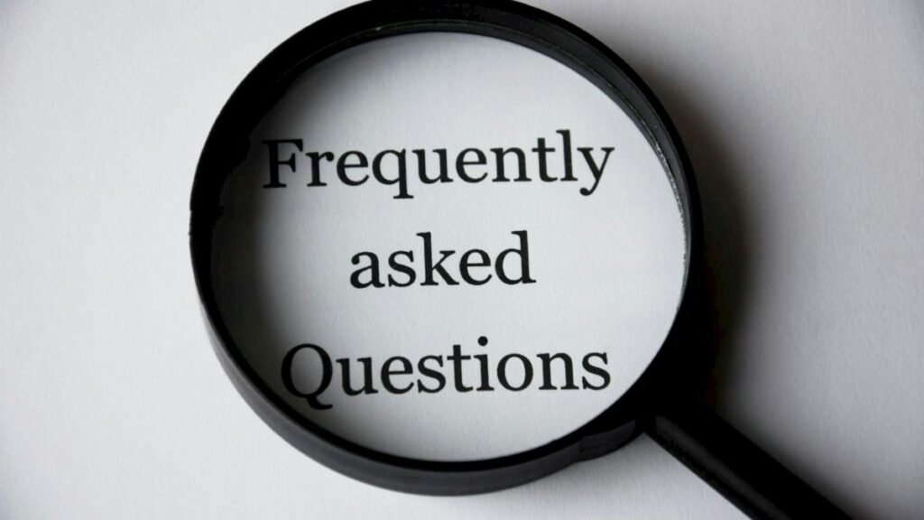 Close-up of a magnifying glass focusing on the phrase 'Frequently Asked Questions'.