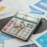 A calculator and real estate flyers depicting financial planning for home buyers.