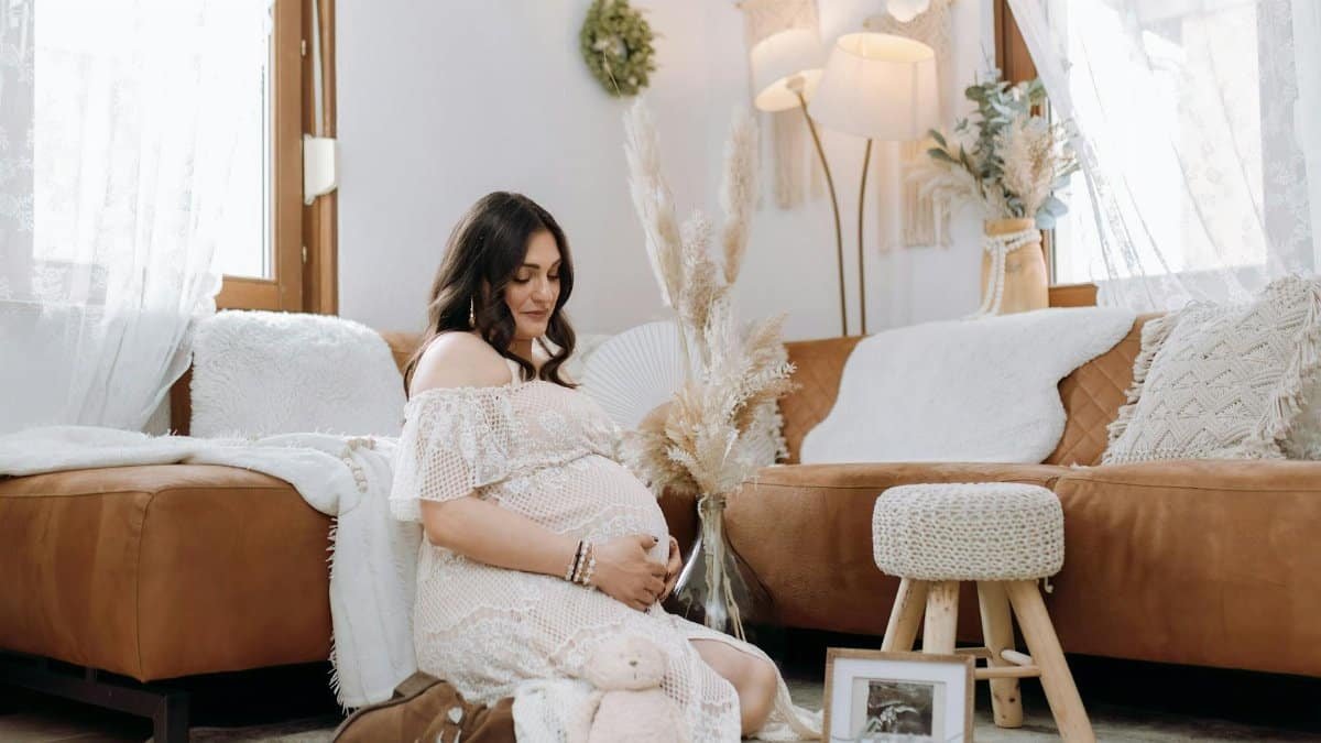 Pregnant woman in a cozy living room setting, embracing motherhood and new life.