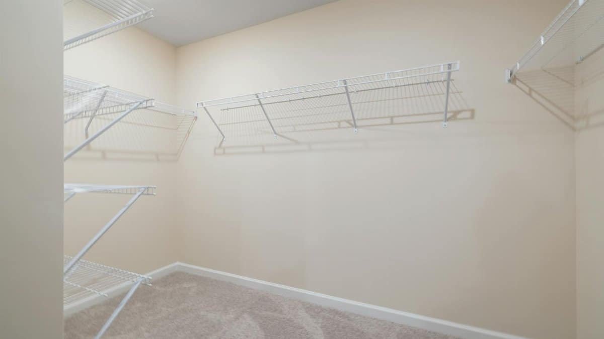 Empty walk-in closet featuring wall-mounted wire shelving, perfect for organization.