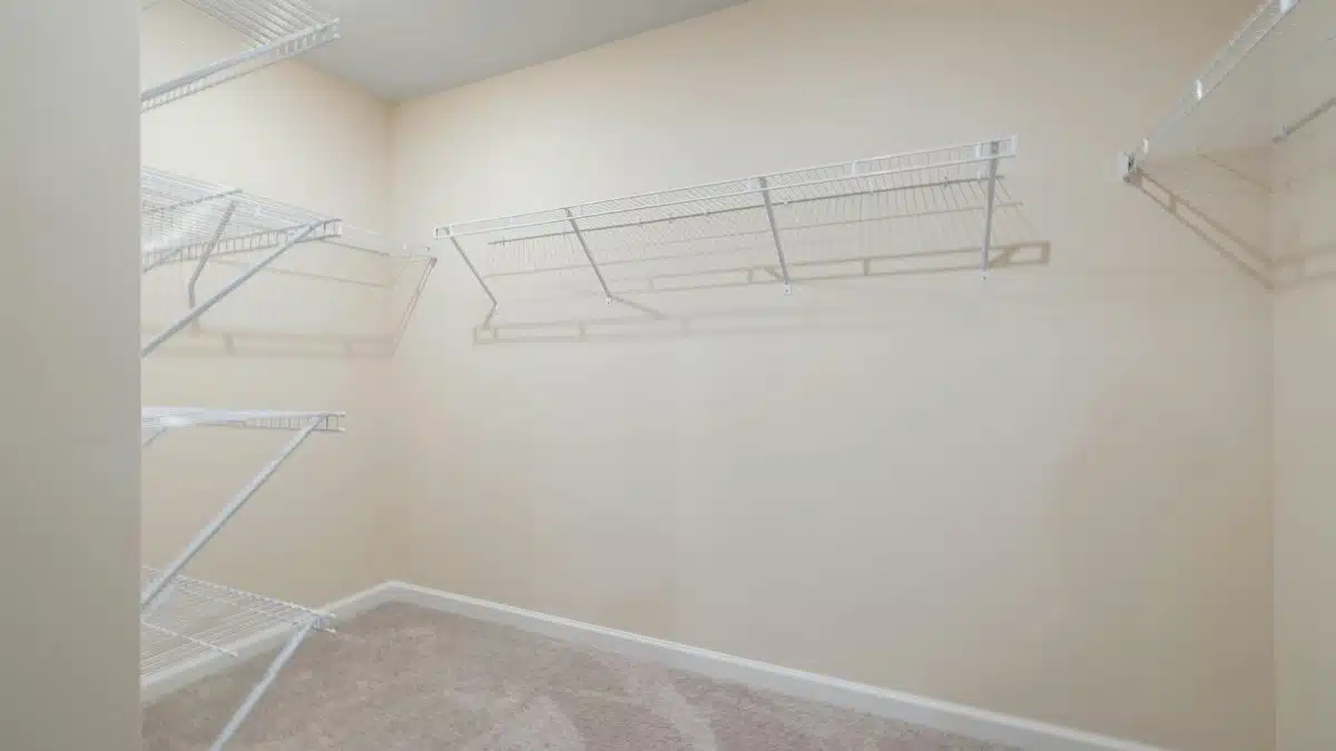 Empty walk-in closet featuring wall-mounted wire shelving, perfect for organization.