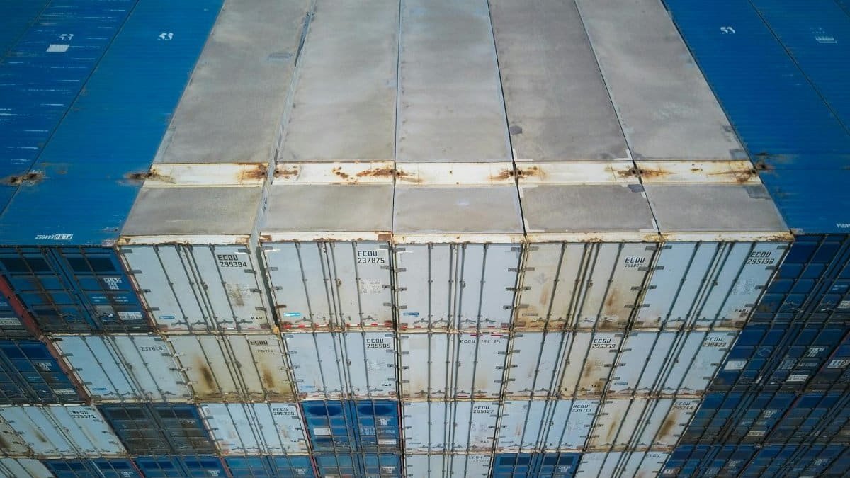High angle shot of multiple stacked shipping containers showcasing global logistics and trade.