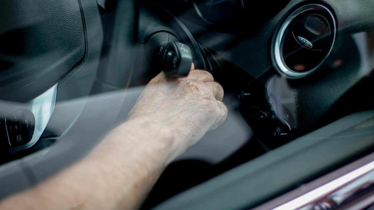 Close-up of a driver's hand starting the car ignition in Leeds, UK.