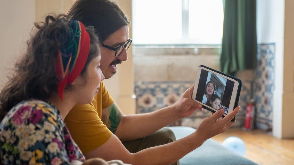A family enjoys a video call at home in Portugal, sharing joyful moments together.