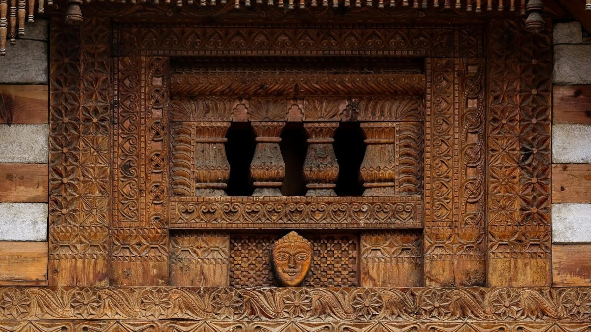 Detailed wooden carving on a traditional Indian temple facade, showcasing ancient architecture.
